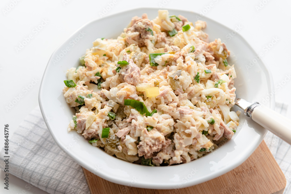 Salad with rice, tuna, egg, pickled cucumber, and chives.