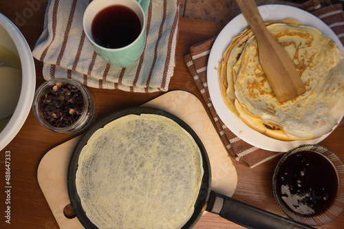 Pancake week. Preparation of dough for baking delicious and ruddy pancakes from the ingredients eggs, flour, butter and milk. Maslenitsa traditional Russian festival meal.