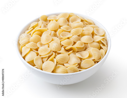 Uncooked orecchiette pasta in white bowl isolated on white background with clipping path