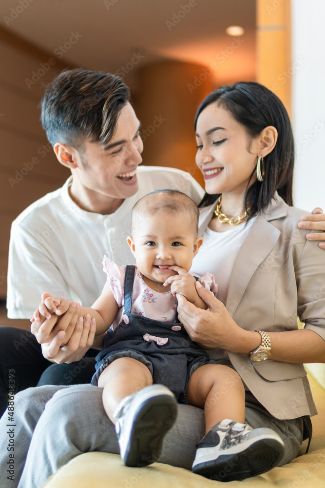 Young malay couple with toddler smiling to each other Young malay couple with toddler smiling to each other