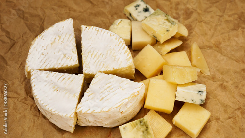 Different varieties of cheese. Soft french cheese of camembert and other types on craft paper