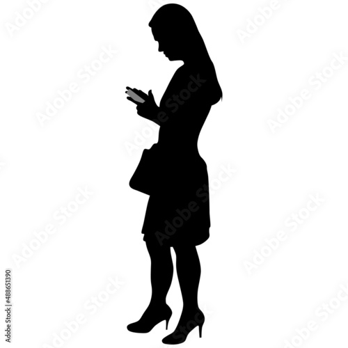 Black silhouette of slender woman with bag, in skirt, in high-heeled shoes with phone in her hands