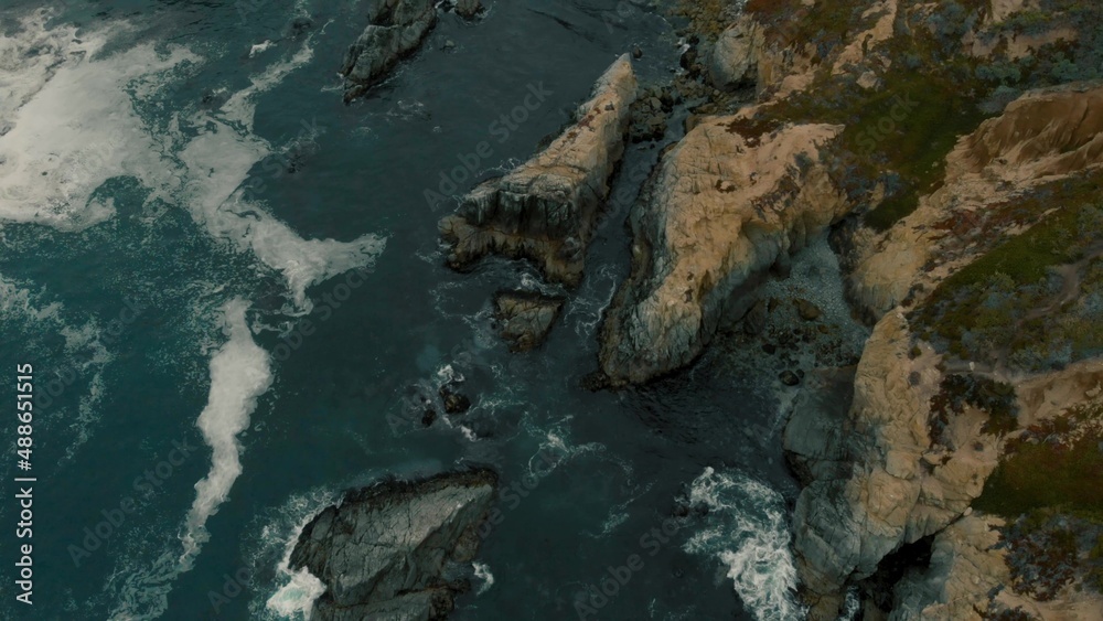 Crystal clear turquoise water, waves crashing on the rocky shore, and the ruins Crystal clear turquoise water, waves crashing on the rocky shore, and the ruins