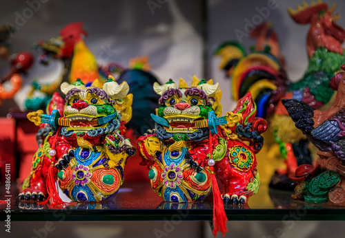 Singapore - September 08, 2019: Pair of Chinese guardian foo dogs with swords souvenir figurines on display at the Chinatown market for sale