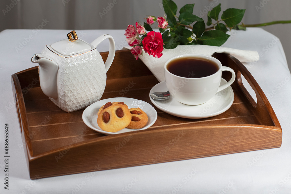 Obraz premium a cup of tea with cookies and a rose on a tray