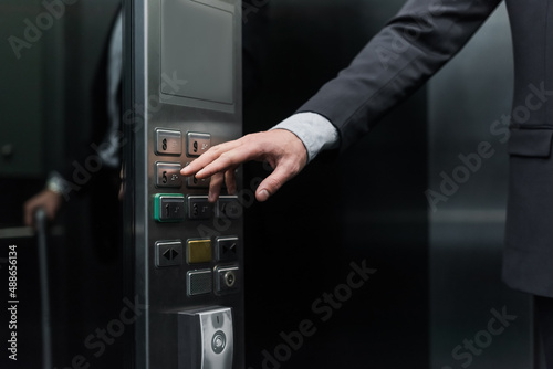 cropped view of man pressing button in modern elevator