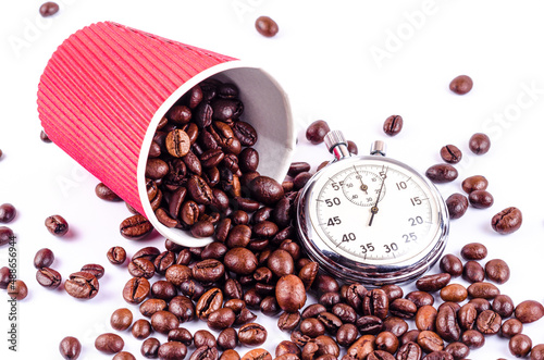Roasted coffee beans fall out of the red cup and stopwatch, it's time to drink coffee