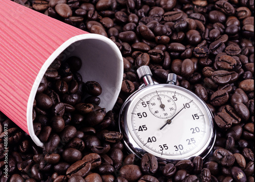 Paper cup of red color and times on a background of coffee beans