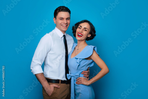 Profile side view portrait of a nice-looking fascinating attractive lovely luxurious smiling couple in love is in an elegant shirt and dress isolated over blue background