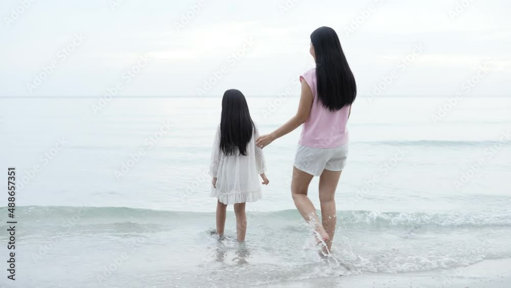 Holiday concept of 4k Resolution. Mother and daughter looking at the view on the beach. Holidays for Asian family travelers. Holiday concept of 4k Resolution. Mother and daughter looking at the view on the beach. Holidays for Asian family travelers.