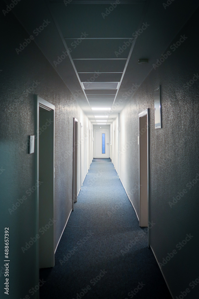 long narrow hallway leads to a white door
