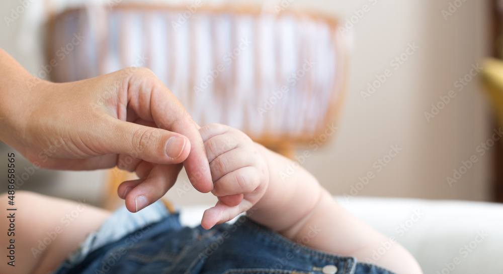Mommy holding the hand of her adorable baby