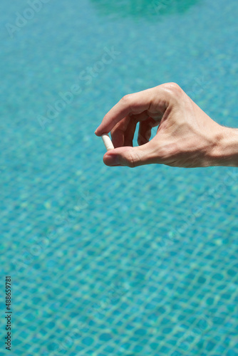  male hand holding a pill pool background © Anna