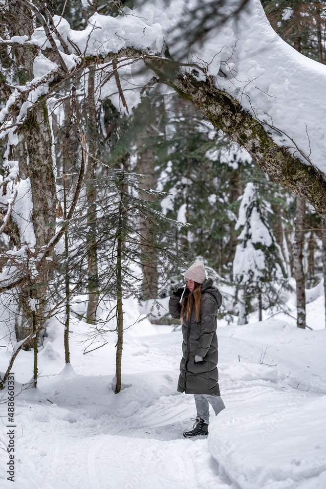 Naklejka premium Girl walking in the snowy forest.