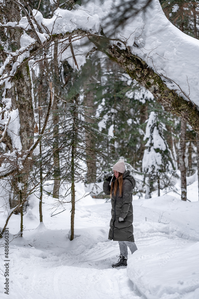 Girl walking in the snowy forest.