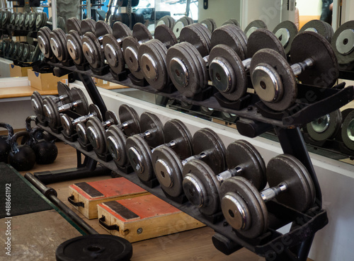 Rows of dumbbells in the gym. Rack with heavy dumbbells in a fitness club. Workout bodybuilding concept.