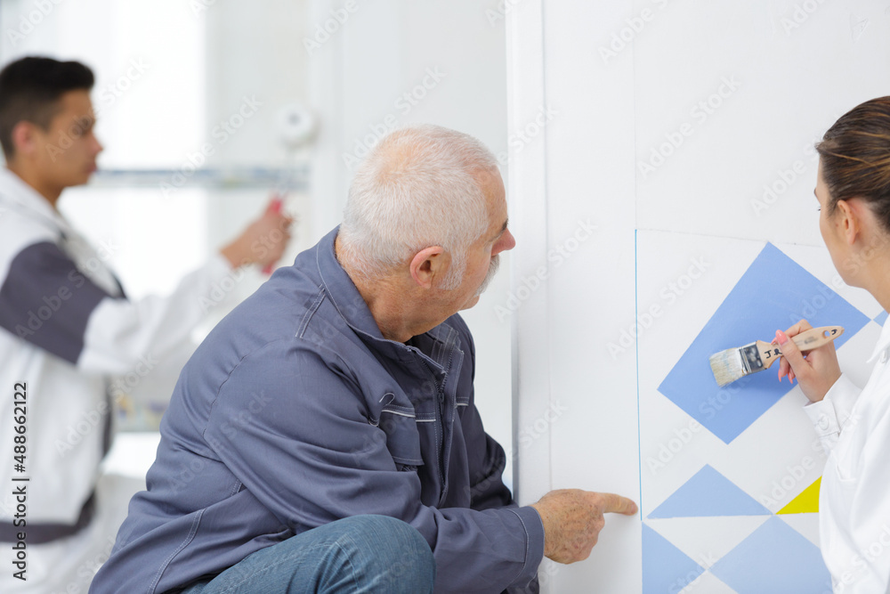 Fototapeta premium teacher guiding a painting apprentice