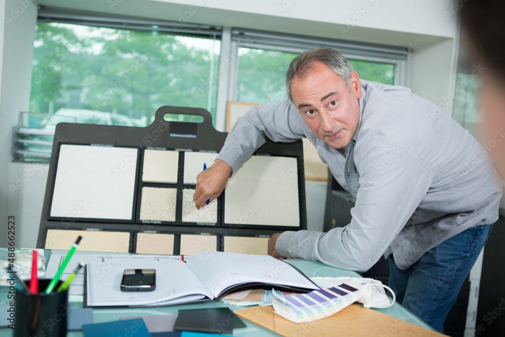 architect pointing at tiles in his office architect pointing at tiles in his office