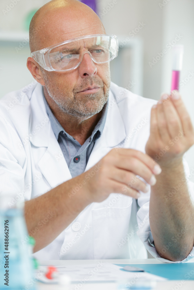 senior scientist holding test tube senior scientist holding test tube