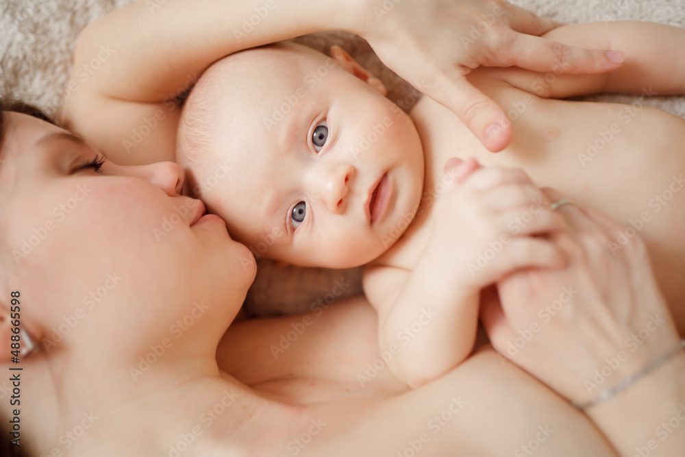 a naked mother and the baby on the bed. maternal and child health. a naked mother and the baby on the bed. maternal and child health.
