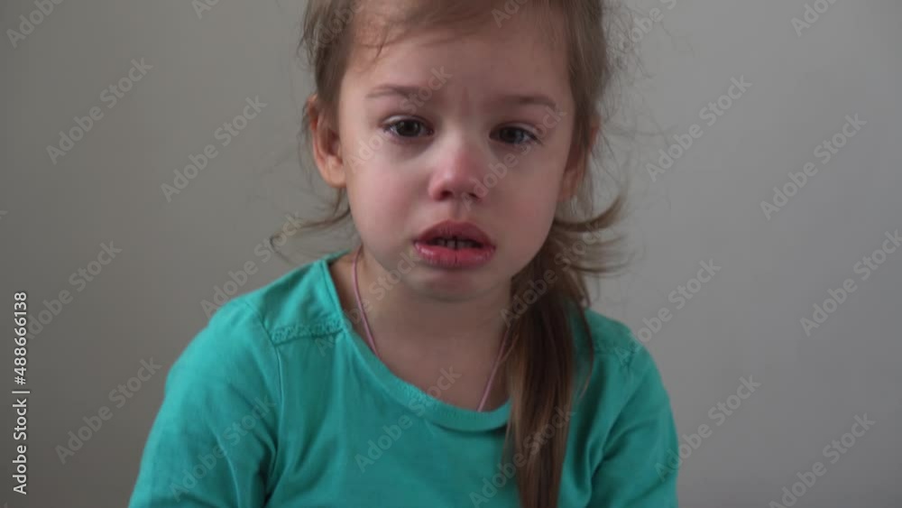 Portrait little girl sad upset child burst into tears cries sob looking at camera indoors. sincere children emotions feelings at home crying kid with pretty face. Concept childhood insult offend grief