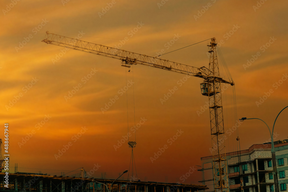 construction crane on the background of the sunset, the concept of building a residential area. construction crane on the background of the sunset, the concept of building a residential area.