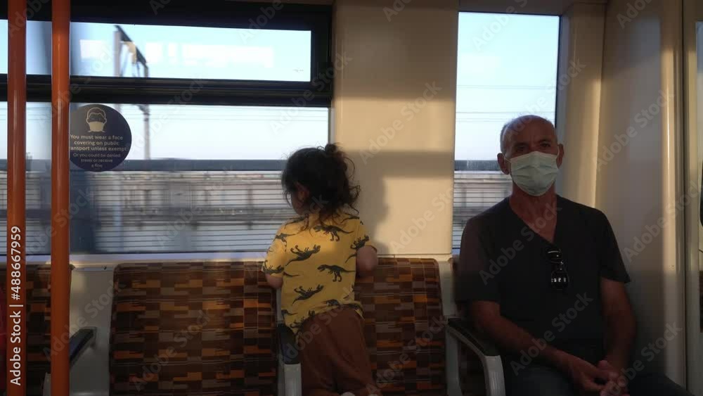 masked senior man and Child on train during covid pandemic masked senior man and Child on train during covid pandemic