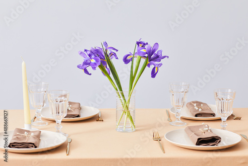 Minimal background image of Spring dinner table decorated with Iris flowers, copy space