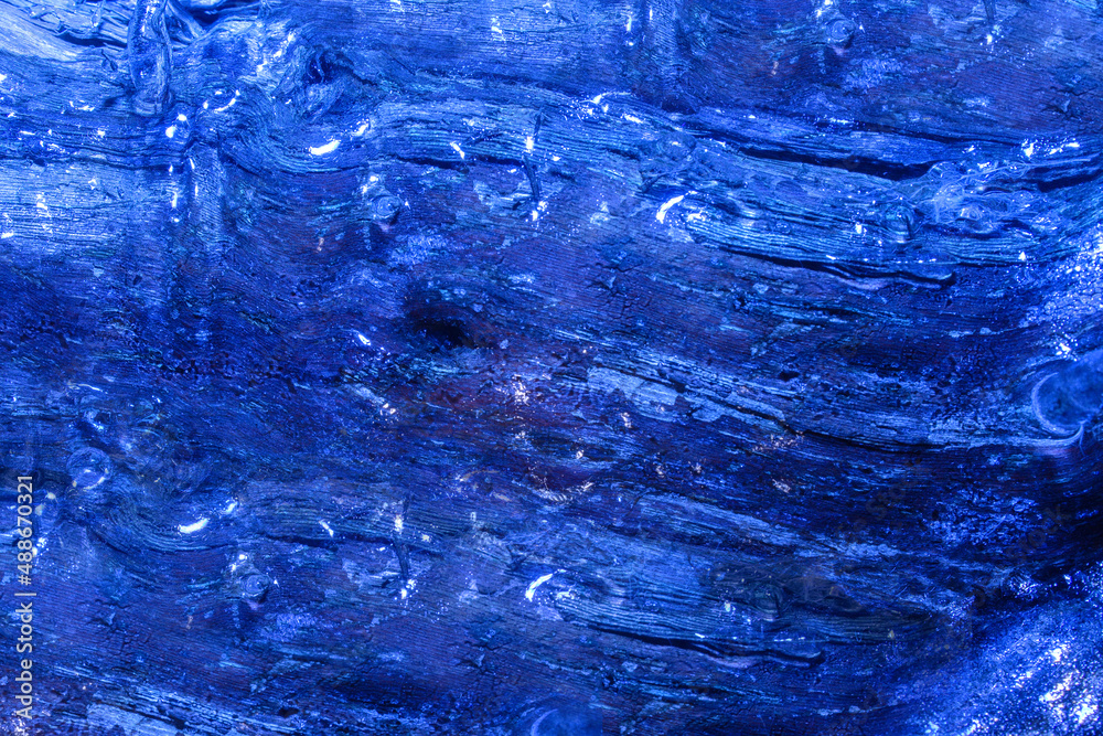 Photo of blue toned frozen wood trunk covered in ice texture. Photo of blue toned frozen wood trunk covered in ice texture.