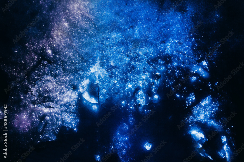 Photo of glowing and highlighted snow surface with ice pieces.
