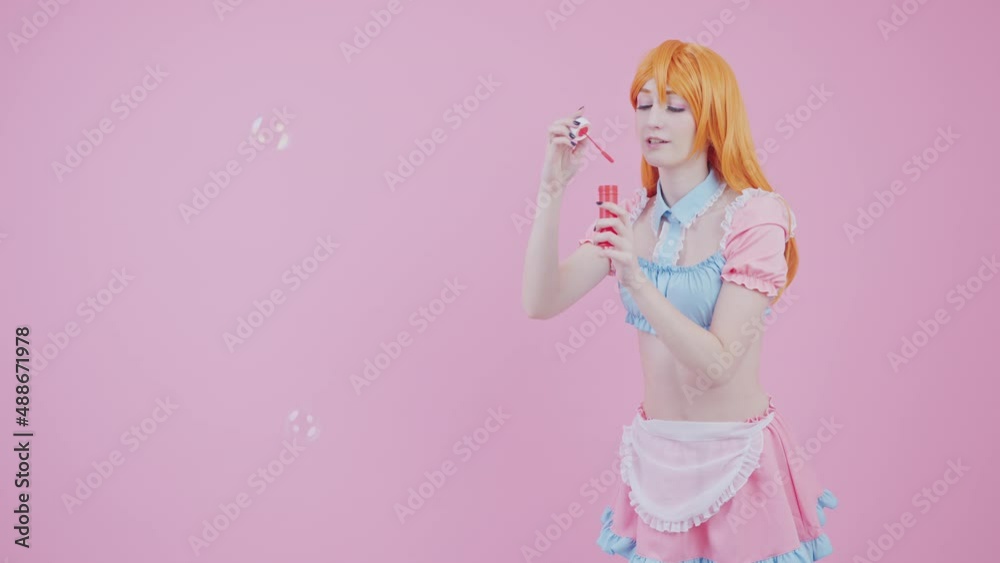 Studio Shot of A Young Kawaii Girl That Blows Soap Bubbles Pink Background. High quality 4k footage Studio Shot of A Young Kawaii Girl That Blows Soap Bubbles Pink Background. High quality 4k footage