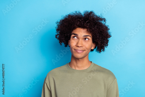 Photo of youth guy curious interested think minded look empty space isolated over blue color background