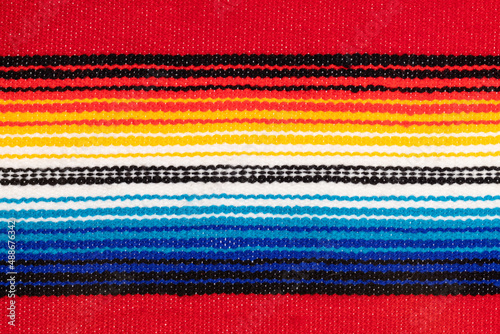 Traditional Colorful Mexican serape fabric, full background. Hand woven Latino blanket with specific vibrant colors.