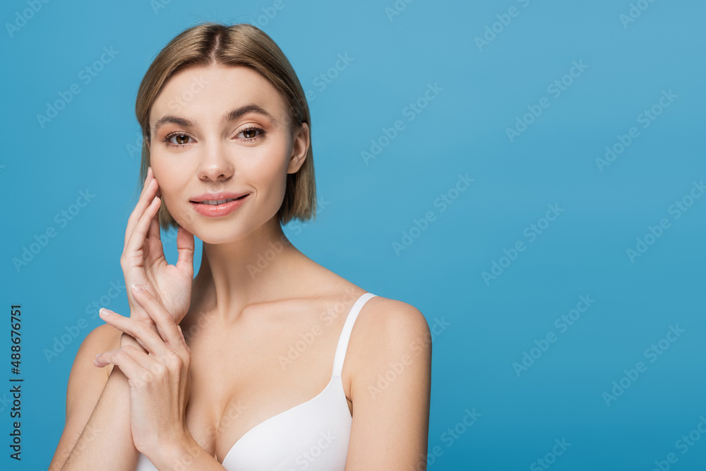 cheerful young woman in white bra smiling isolated on blue cheerful young woman in white bra smiling isolated on blue