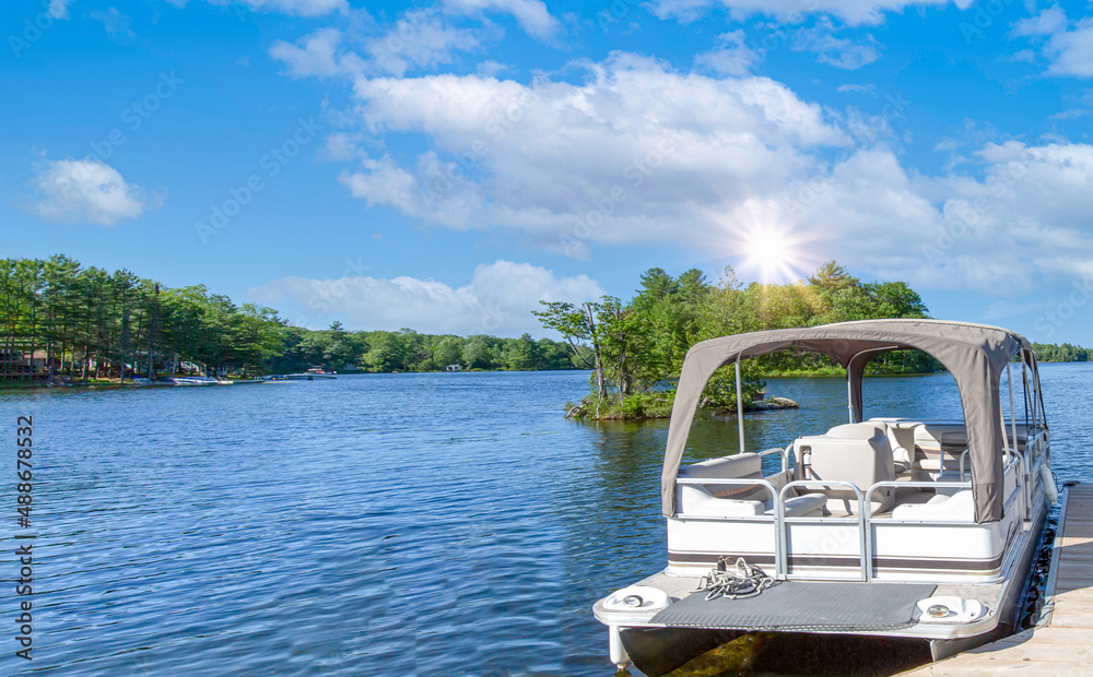 Naklejka premium A boat waiting for a ride on a lake near Georgian Bay and Blue Mountain resort in Muskoka, Ontario.