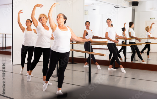 Obraz na plátně Warm-up sessions at the bench, women doing ballet
