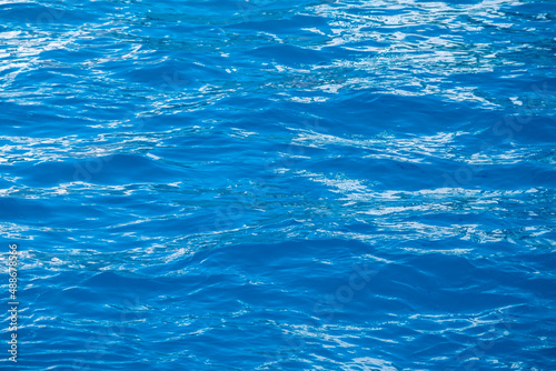 Aqua blue color water surface. Vacation near sea, okean. Vivid, bright ripple texture. Copy space, top view.