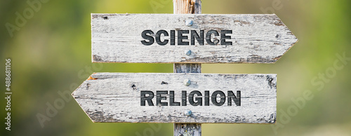 opposite signs on wooden signpost with the text quote science religion engraved. Web banner format.