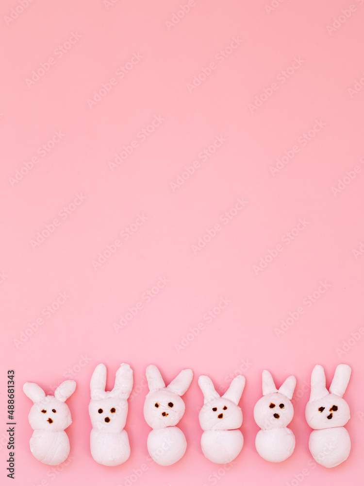 White handmade marshmallow candy bunnies on pink paper background with copy  space for your Easter text message. Minimal happy Easter holiday conceprt.  Top view flat lay, border frame, vertical Stock Photo |