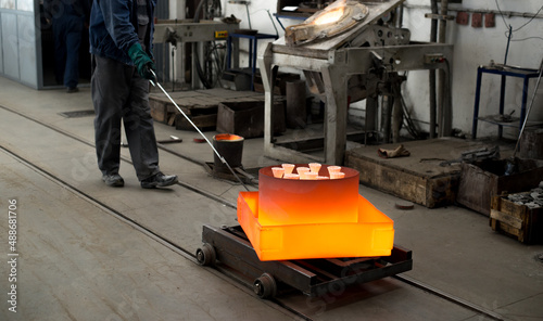 Photos Workers molding objects in the foundry, pouring melted metal in molds
