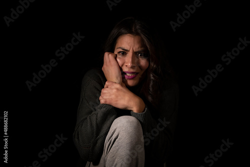 Latin young woman suffering depression on isolated black background © alejandro