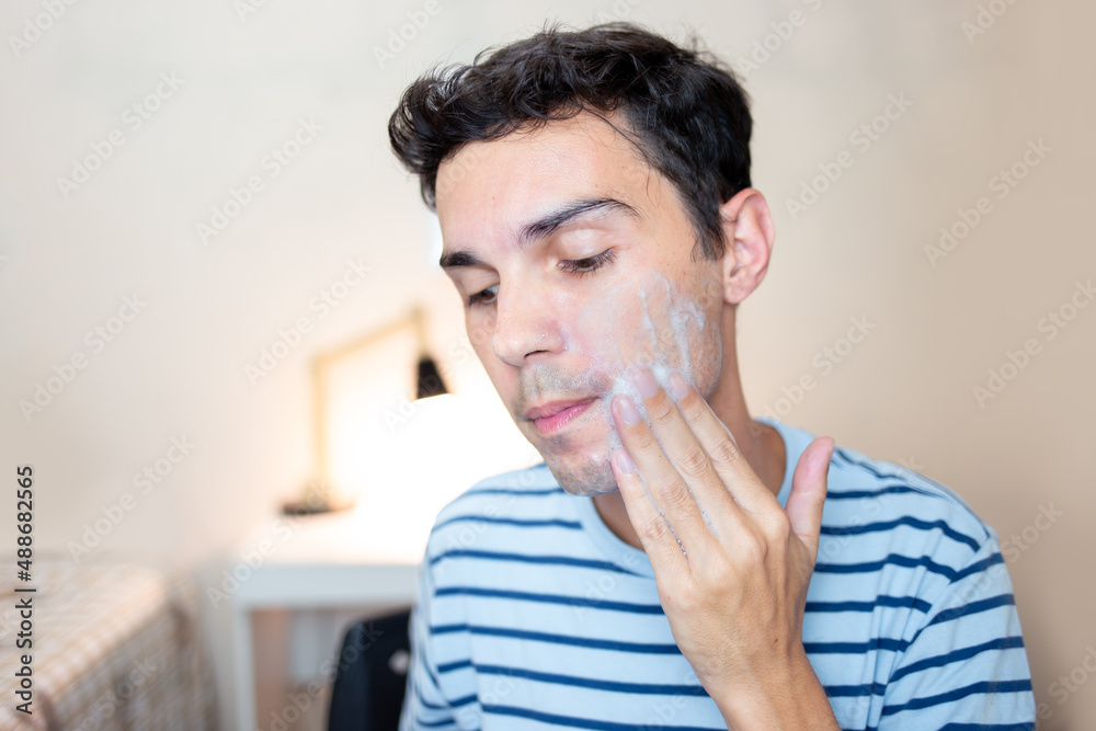 Young man applying facial cream on face. Caring for the skin of the face with skin care products. Young man applying facial cream on face. Caring for the skin of the face with skin care products.
