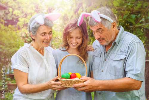 Happy family looking into Easter eggs outdoor