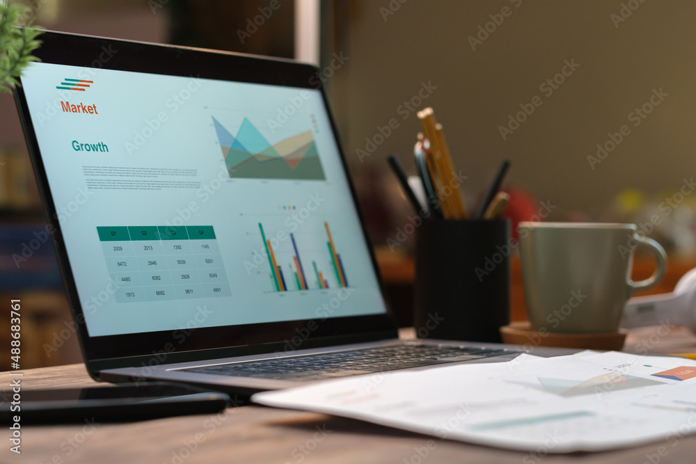 laptop with paperwork on wood table in living room at home.work at home laptop with paperwork on wood table in living room at home.work at home