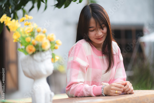 young happy woman person smiling with pink flower blooming, pretty cute girl portrait in summer with nature flower plant in pink color and colorful natural outdoor