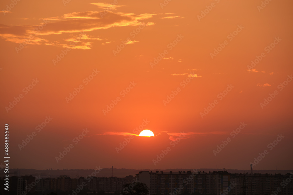 Fototapeta premium Bright colorful sunset sky with rays of setting sun and vivid dark clouds