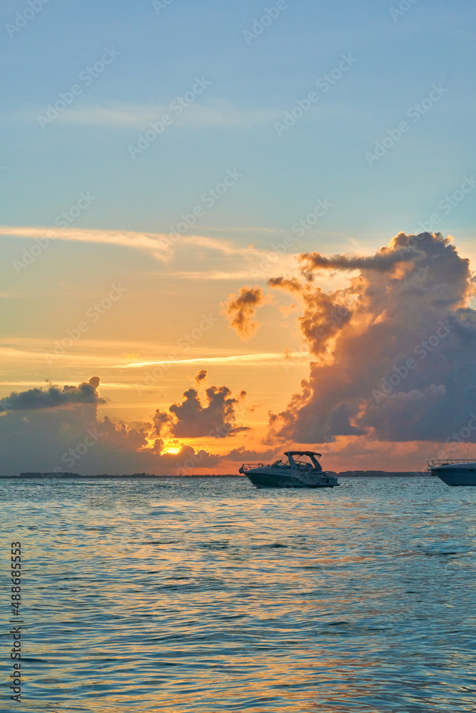 boat at sunset on the north beach of isla mujeres, Cancun.Spectacular sky with lots of blue and orange clouds.