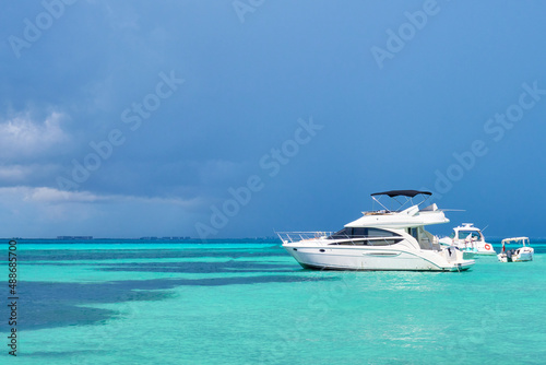 yacht in north beach of isla mujeres, Cancun, Mexico.Blue sky with rain nearby and turquoise blue sea water. Mexican Caribbean beaches. © Israel Solorzano