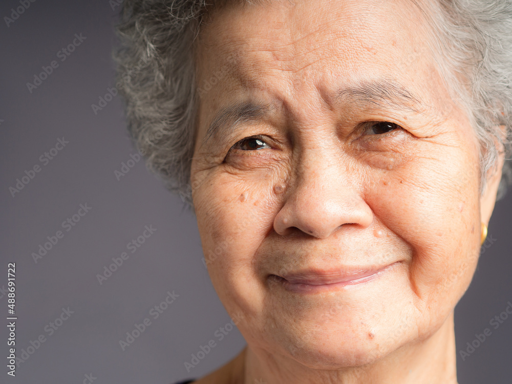 Fototapeta premium Close-up face of a smiling senior woman and looking at the camera