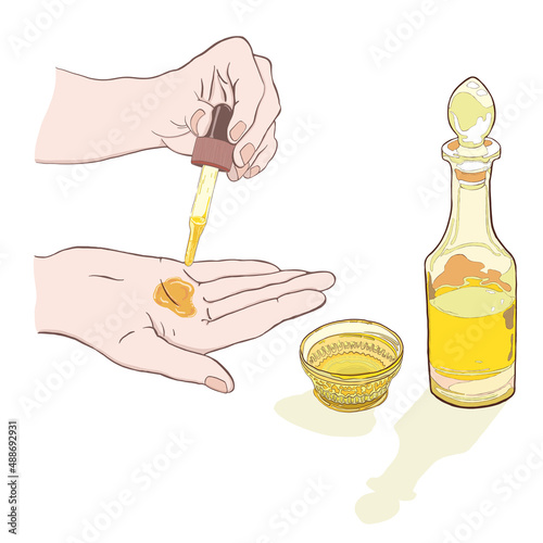 スポイトを持ってオイルを掌に垂らす様子・植物油・ガラス瓶